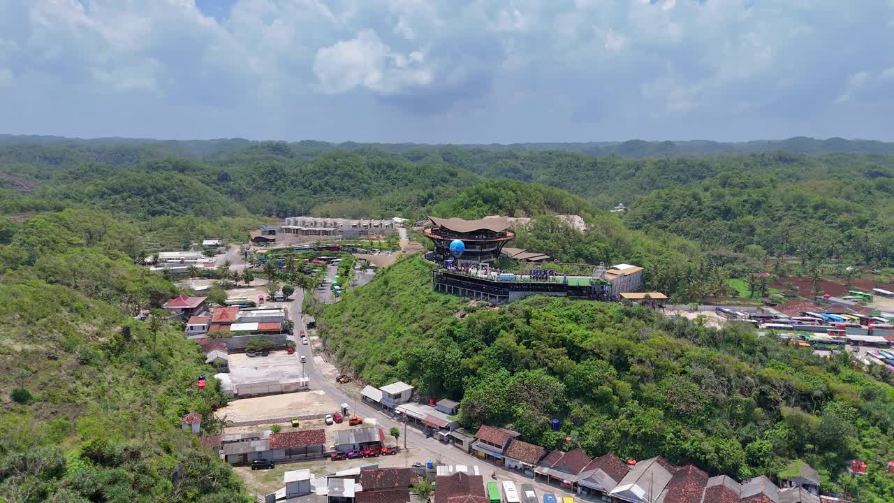Aerial scenery of Building on the hill top surrounded by greenery forest and hills. Drini Park, Drini Beach, Indonesia