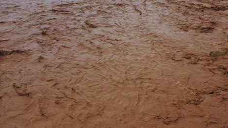 aerial of flood waters moving fast down the ventura river in california with runoff during winter weather flooding 3