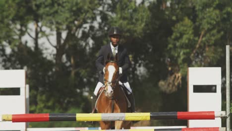 Hombre-Afroamericano-Saltando-Un-Obstáculo-Con-Su-Caballo-De-Doma