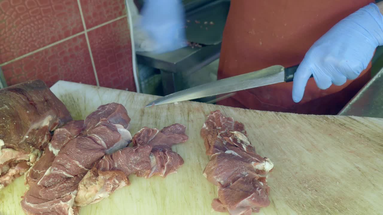 Butcher Sharpening Knife and Preparing Raw Meat in a Shop
