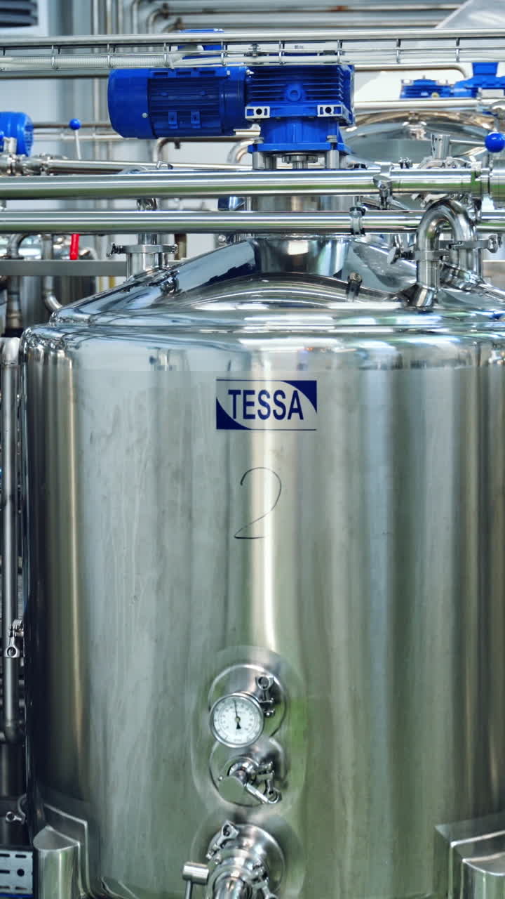 Manufacturing plant inside. Production of dairy cheese in a modern factory. Manufacturing of dairy products. Milk products inside big bowls. Vertical video