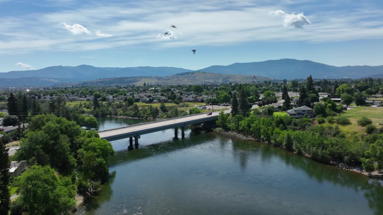 toma aérea empujando hacia un puente sobre el río spokane con pájaros volando a través de la toma