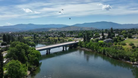 Aerial-shot-pushing-towards-a-bridge-over-the-Spokane-River-with-birds-flying-through-the-shot