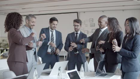 relaxed office managers cheering with beer bottles