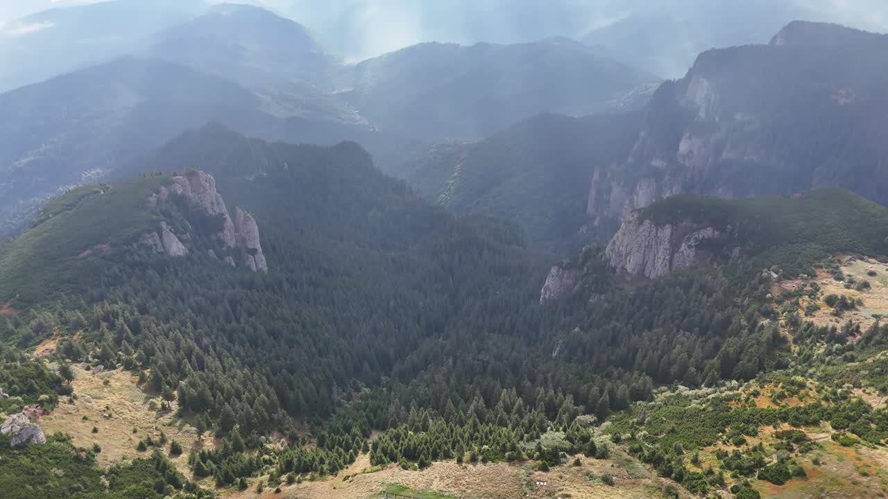 Aerial View of Majestic Mountains and a Cabin in the Forest