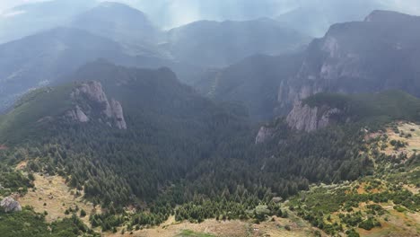 aerial view of majestic mountains and a cabin in the forest