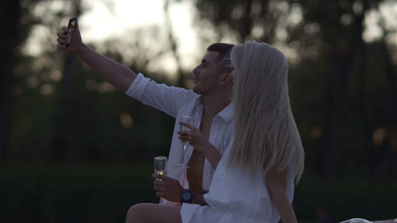 Coppia romantica che scatta un selfie di sera. Amanti che catturano un momento felice.