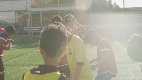 soccer kids having fun with water in a sunny day