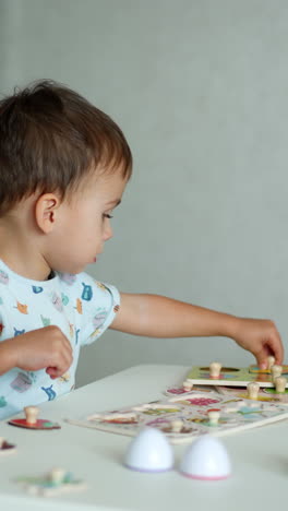 year and half toddler playing with puzzles. lovely kid studying through a game. vertical video