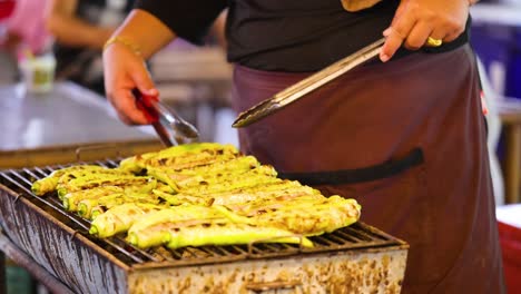 vendor grilling skewers at floating market