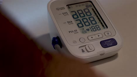 digital blood pressure monitor measuring blood pressure with a white background