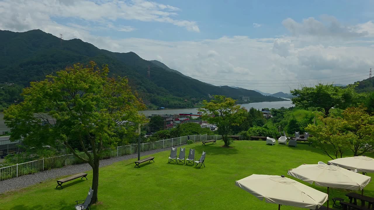 Overlooking the Bukhangang River and Hwayasan Mountain on a sunny day. Beautiful scenic view from a terraced hillside cafe in Gapyeong, South Korea