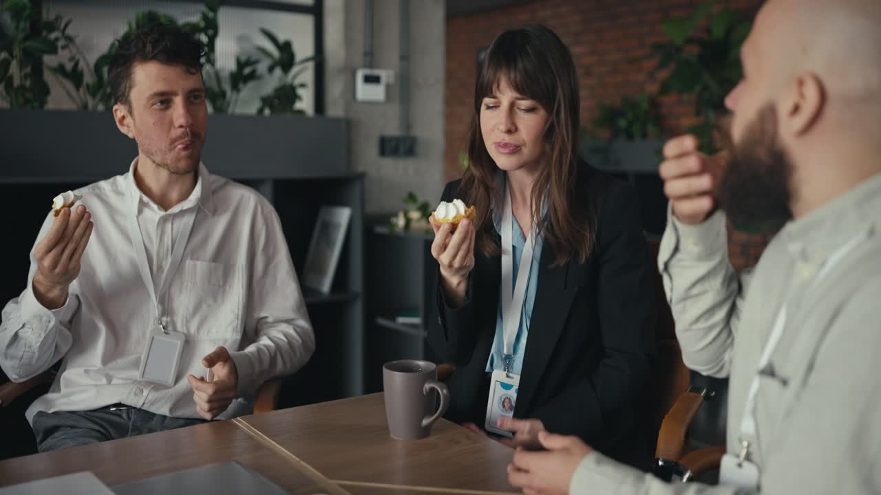 Employees eating cupcakes at a business meeting