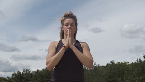 Woman-standing-peacefully-with-folded-hands