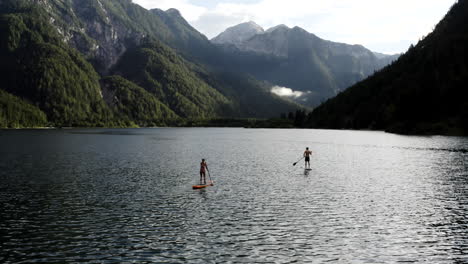 couple paddleboarding on a mountain lake