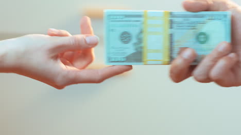 a latino male hands a caucasian woman a key, in exchange for a stack of cash