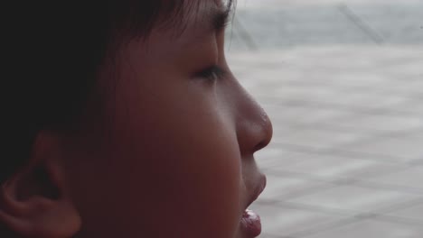 boy outdoors alone breathing heavily close up after running with sweat beads collected on the top of his nose