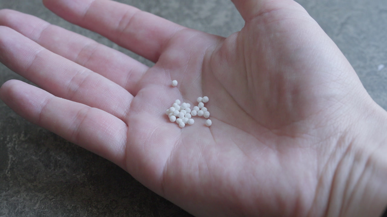 Putting homeopathic pills from a small bowl onto hand