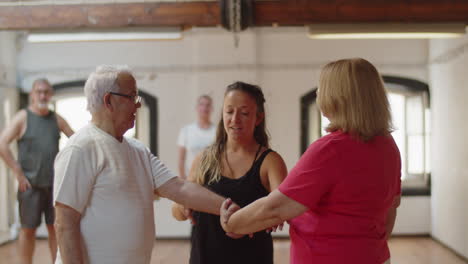 front view of dance teacher teaching senior couple how to move