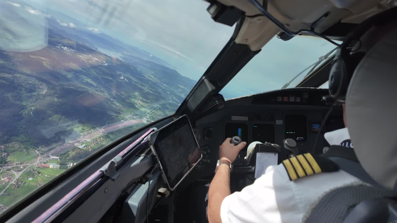 an immersive view of a caucasian male pilot flying manually a jet airplane over a rural landscape in North Spain. Captain is piloting the plane in a left turn.