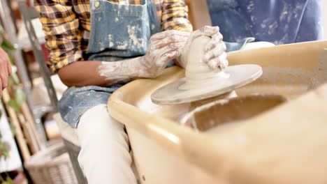 African-american-male-potter-using-potter's-wheel-in-pottery-studio,-slow-motion