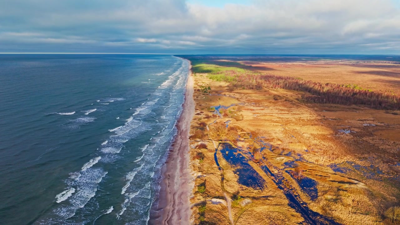 Filmatisk baltisk kystlinje mellom Nida-myren og havet i gyllent lys