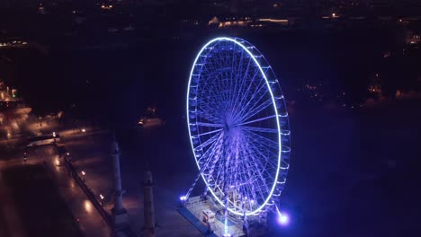 rueda de la fortuna vacía en la plaza por la noche sin gente y luz azul desde una perspectiva aérea