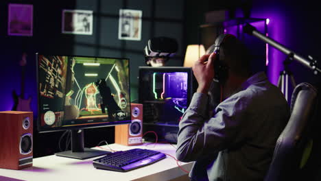 man having fun playing videogames on pc while chatting with teammates