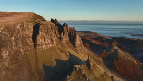 Ancient-crumbling-rocky-spires-in-early-morning-light-with-reveal-of-larger-landslip-moorland-area,-The-Quiraing,-Isle-of-Skye,-Western-Highlands,-Scotland,-UK