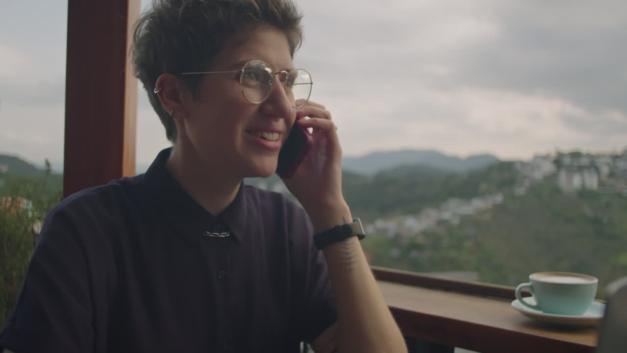 Businesswoman Calling on Phone in Cafe with Mountain View