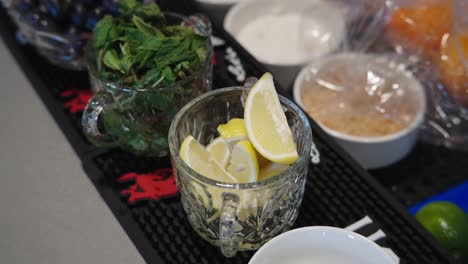 cups filled with lemons, cilantro, with the camera tilting down to a bowl