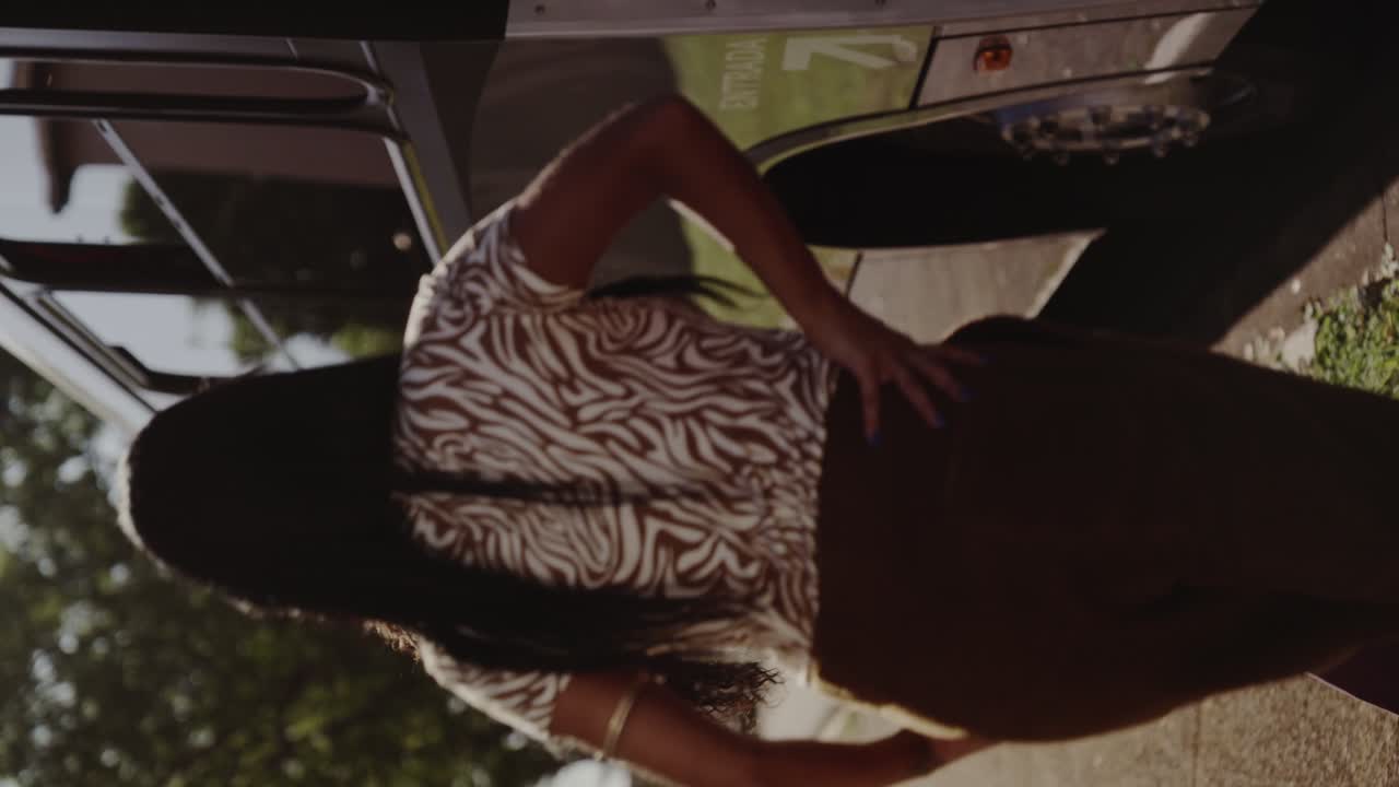 Friends walking and interacting near a bus on a sunny day