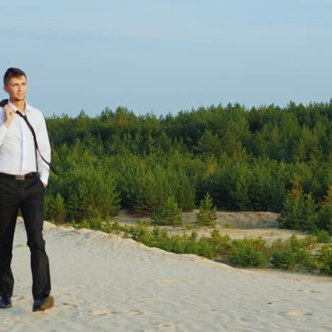 A-satisfied-and-happy-businessman-walks-on-the-sand