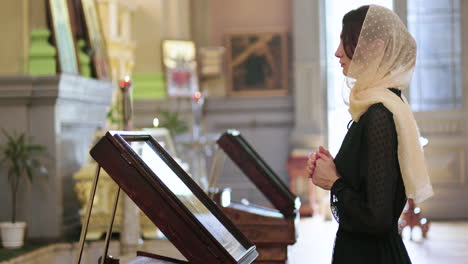 mujer orando en la iglesia