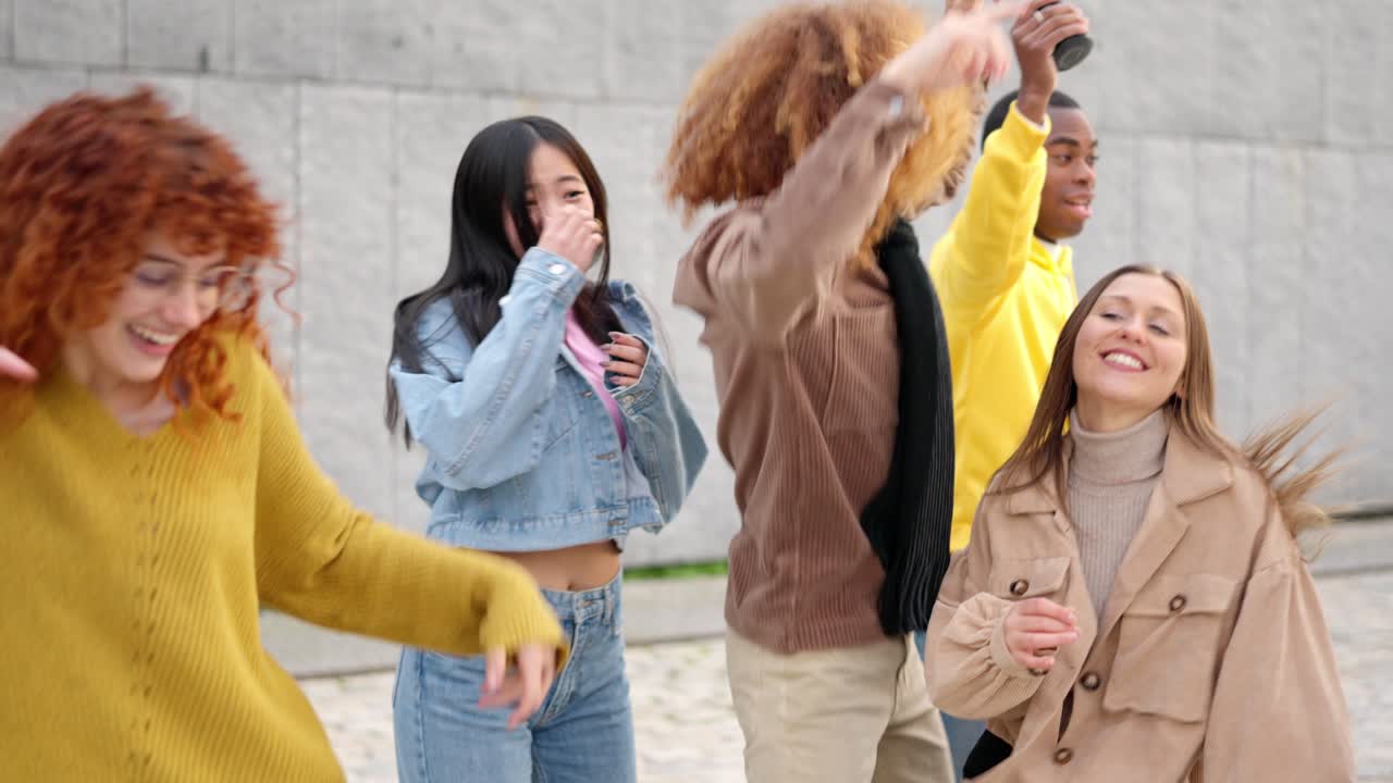 Multi-ethnic friends enjoying dancing and celebrating together in the city