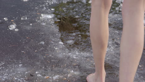 SLOW-MOTION---Beautiful-legs-of-a-young-woman-walking-into-icy-water