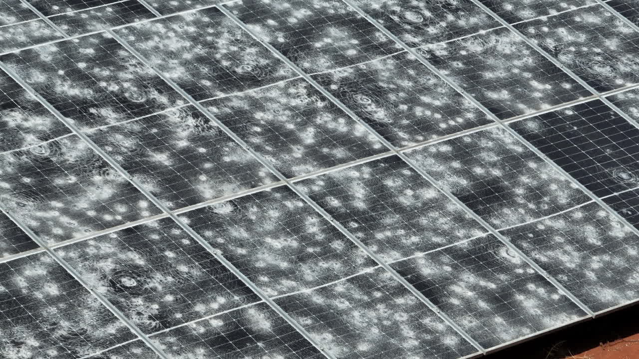 I pannelli fotovoltaici mostrano gravi danni da grandine in una vista aerea ravvicinata, evidenziando superfici frantumate, perdita di infrastrutture e rischio per l'energia rinnovabile