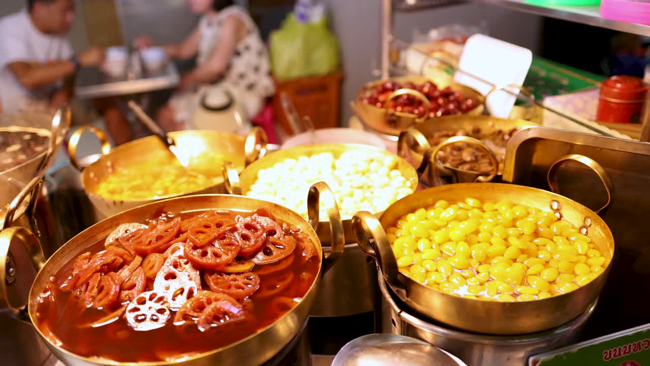 Colorful pots of assorted beans in syrup, vibrant lighting, handheld camera, bustling Bangkok street scene