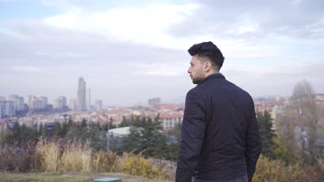 en el centro, el hombre mira a su alrededor impotente. urbanización ciudad gris. infelicidad, insatisfacción.