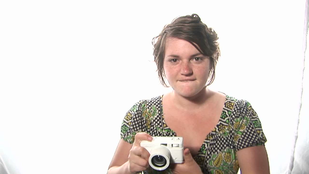 여자는 카메라로 사진을 찍는다