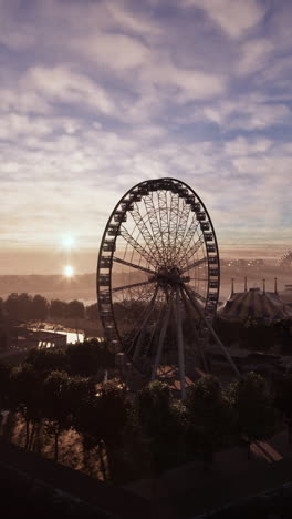 vista del amanecer de una rueda de ferris en un parque de atracciones