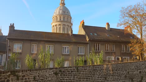 shot of the basilica of notre-dame dome rising above the rooftops of boulogne-sur-mer, france. the video captures the architectural contrast between the historic dome and the surrounding urban;