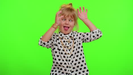 funny child kid girl making playful silly facial expressions and grimacing, fooling, showing tongue