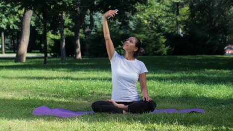 girl sitting on a mat and doing selfie with smart (1) | fitness, girl, meditating, meditation