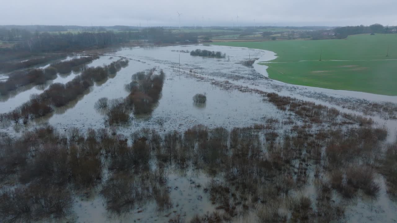 봄의 높은 물, 알란데 강 홍수, 갈색과 진 물, 물 아래의 농장, 흐린 날, 넓은 드론 촬영