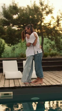 couple hugging by the pool at sunset