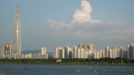 koreans windsurfing on han river, lotter tower on background at summer day static copy space