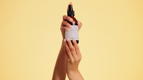 manos, spray y botella con belleza