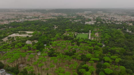 Vista-Panorámica-Aérea-De-Un-Gran-Parque-En-La-Ciudad-En-Un-Día-Nublado.-Vuela-Alto-Por-Encima-De-Los-árboles-Crecidos-En-El-Parque-De-Villa-Borghese.-Roma,-Italia