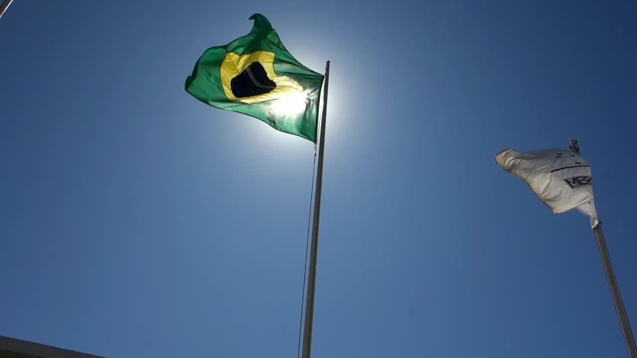 Bandeiras do Brasil e do Mercosul tremulando em frente ao Palácio do Planalto, sede da Presidência da República do Brasil, em Brasília
